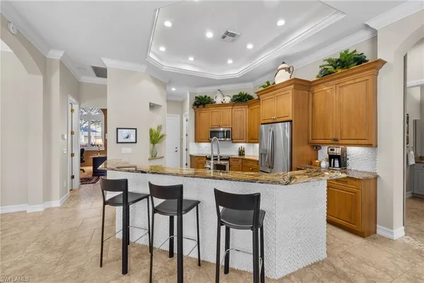 a large kitchen with stainless steel appliances granite countertop a refrigerator and a sink