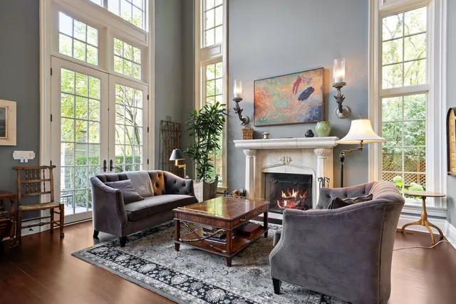 a living room with furniture a fireplace a flat screen tv and a large window
