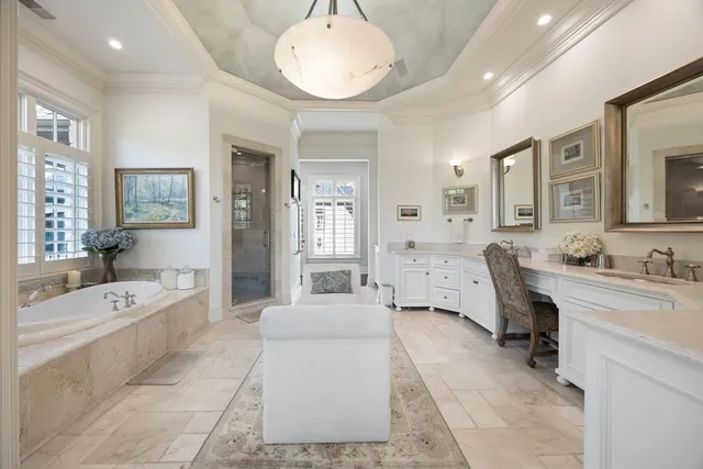 a spacious bathroom with a tub double vanity sink and a mirror