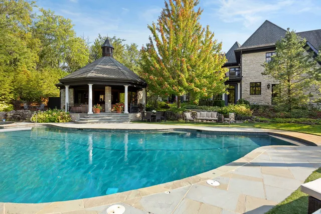 a view of a house with pool lawn chairs and a yard