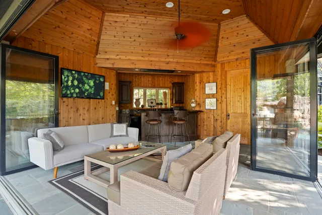 a living room with furniture a flat screen tv and a large window