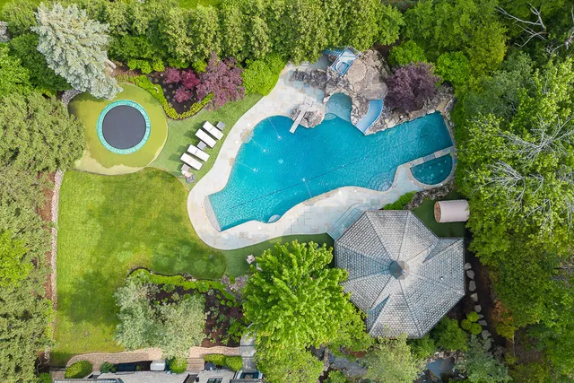 an aerial view of a swimming pool patio outdoor seating and yard