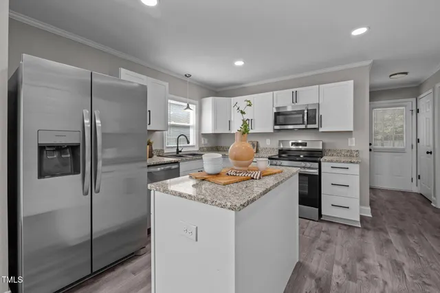 a kitchen with stainless steel appliances granite countertop a sink stove and microwave