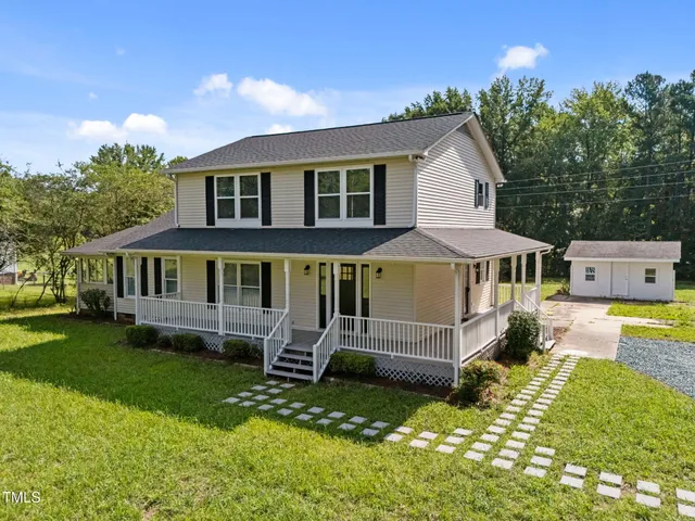a front view of a house with a yard table and chairs