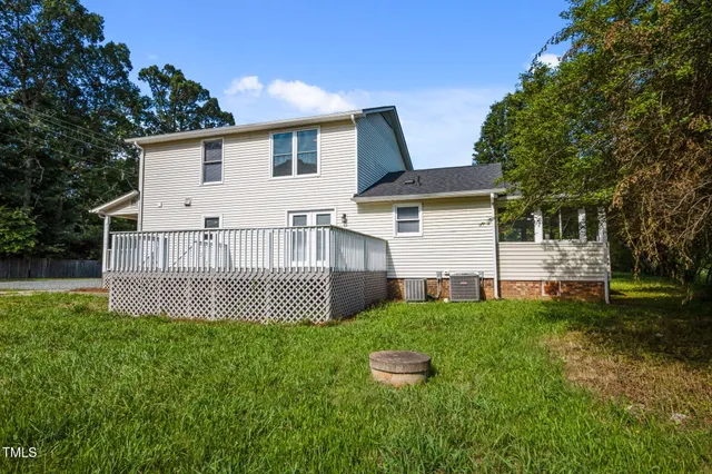 a view of a house with a yard and a large tree