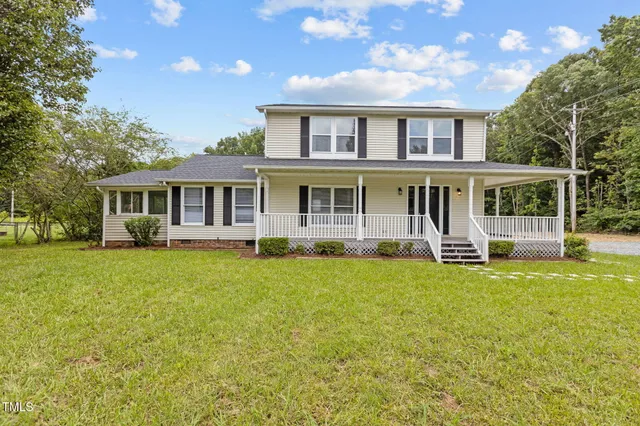 a front view of a house with a yard and trees