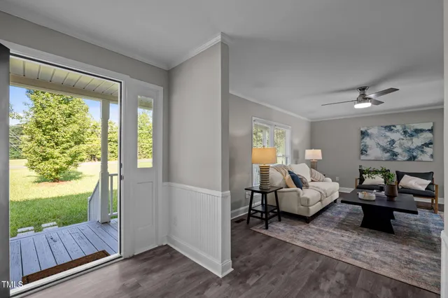 a living room with furniture floor to ceiling window and wooden floor