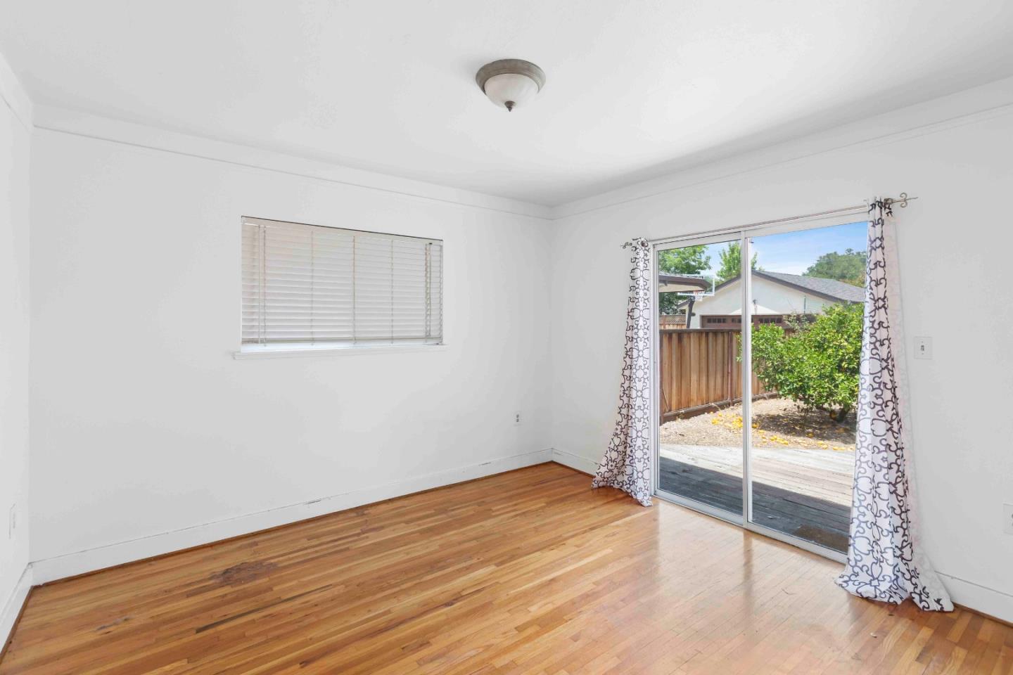 16735 Shannon Road Los Gatos, CA 95032 - Photo 9 of 19 an empty room with wooden floor and windows