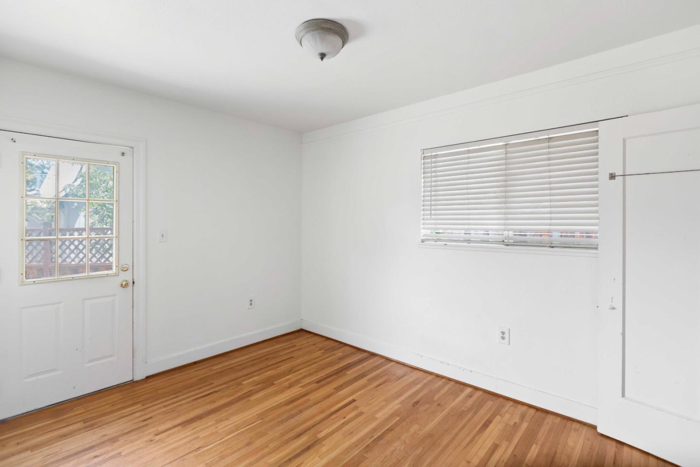 16735 Shannon Road Los Gatos, CA 95032 - Photo 10 of 19 an empty room with wooden floor and windows