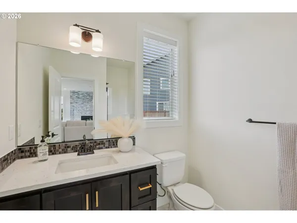 a bathroom with a sink a toilet a mirror and a window