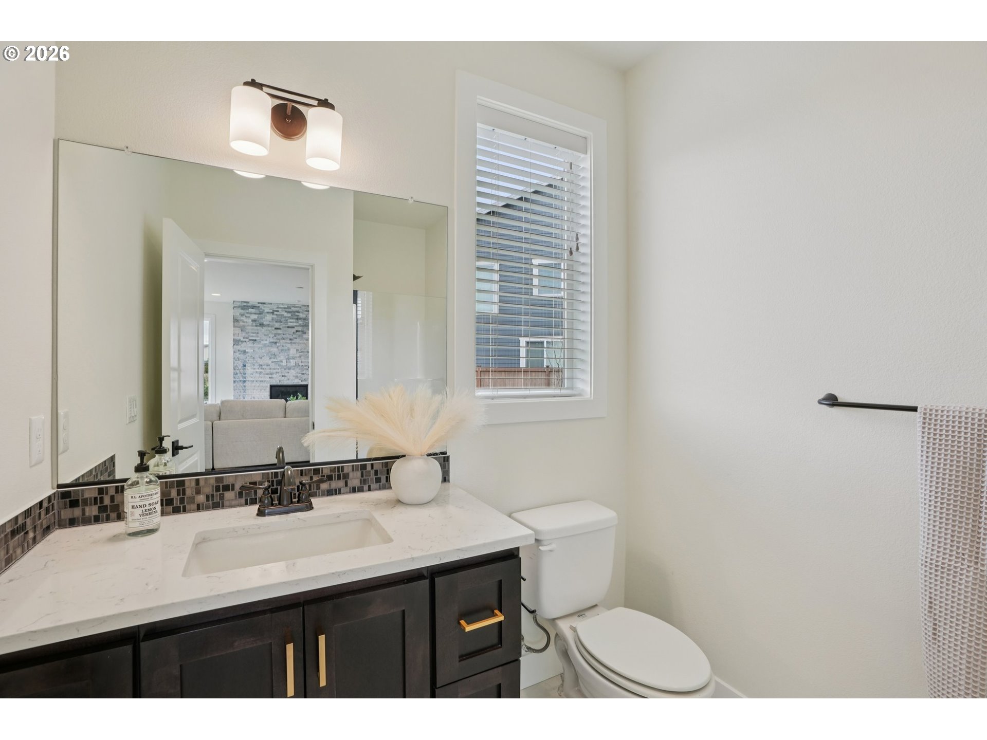 3809 Southeast Reed Drive Hillsboro, OR 97123 - Photo 19 of 40 a bathroom with a sink a toilet a mirror and a window