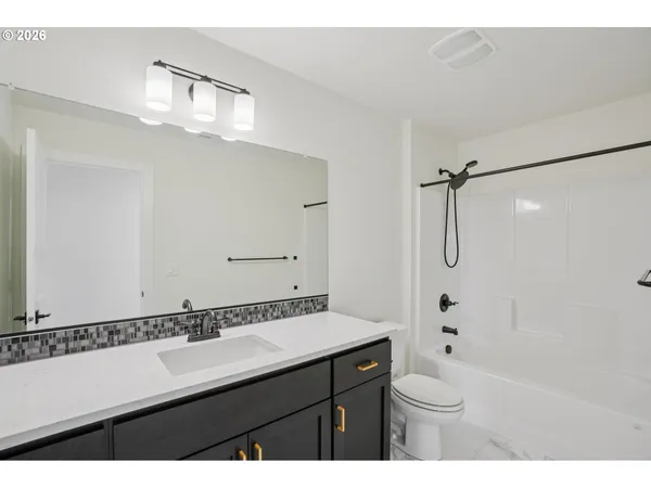 a bathroom with a sink a toilet a mirror and shower
