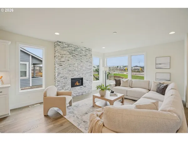 a living room with furniture potted plant a fireplace and a window