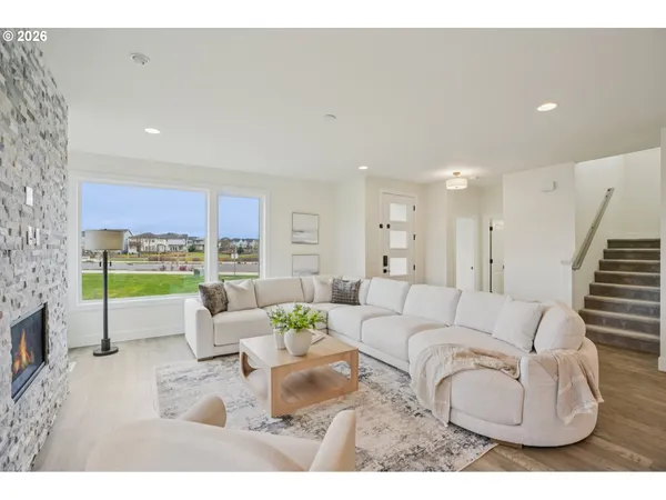 a living room with furniture and a floor to ceiling window