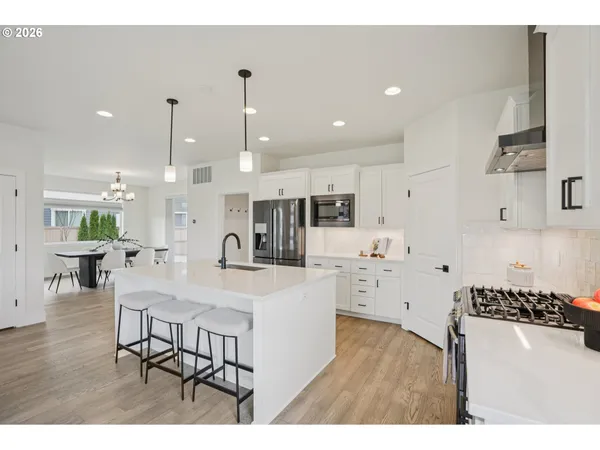 a large kitchen with a table and chairs