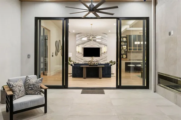 a living room with furniture large window and glass door