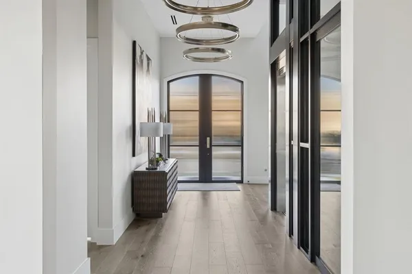a view of a hallway with wooden floor and furniture