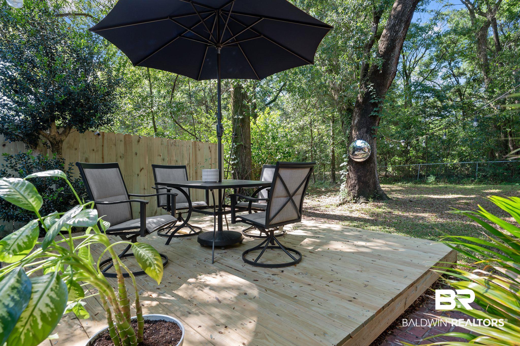 4724 Wicker Way Mobile, AL 36609 - Photo 18 of 36 Expansive outdoor deck featuring natural wood planks, bordered by a privacy fence, and surrounded by mature trees
