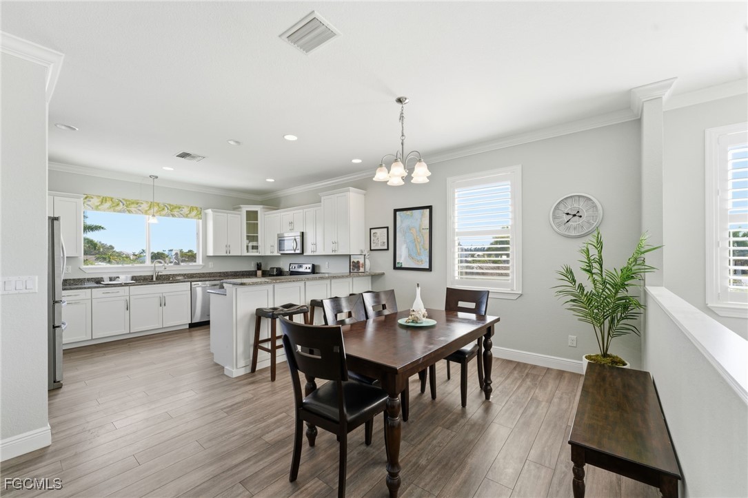 12304 Boat Shell Drive Matlacha Isles, FL 33991 - Photo 18 of 49 a view of a dining room with furniture window and wooden floor