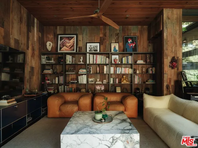 a living room with furniture a bookshelf and a shelf