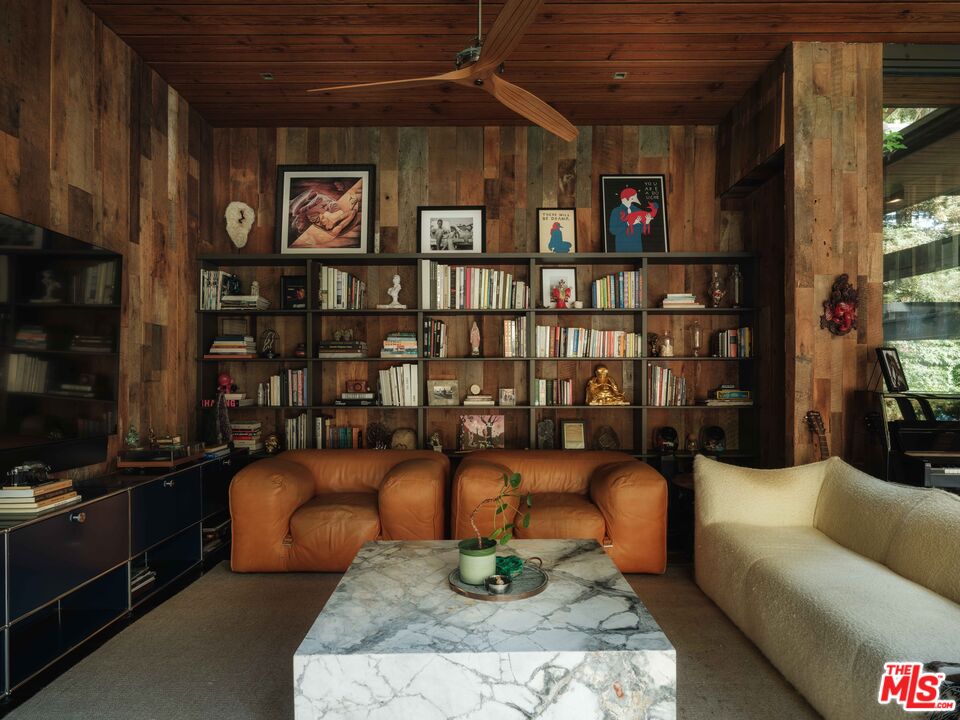 2563 Nichols Canyon Road Los Angeles, CA 90046 - Photo 12 of 32 a living room with furniture a bookshelf and a shelf