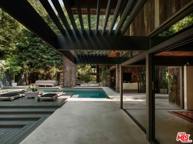 a view of a patio with table and chairs a barbeque with wooden fence and floor