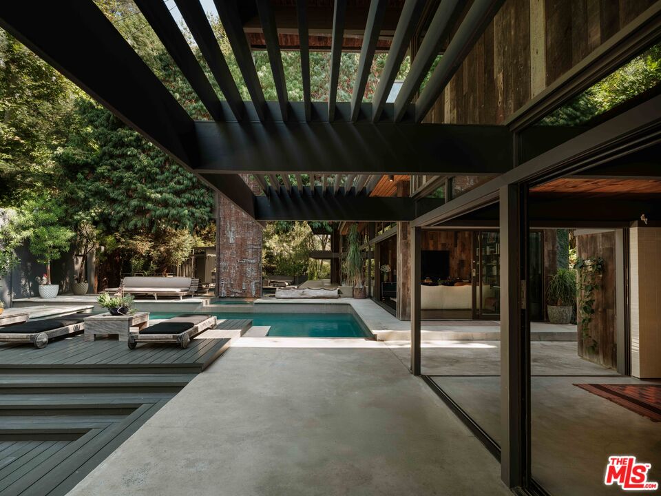 2563 Nichols Canyon Road Los Angeles, CA 90046 - Photo 3 of 32 a view of a patio with table and chairs a barbeque with wooden fence and floor