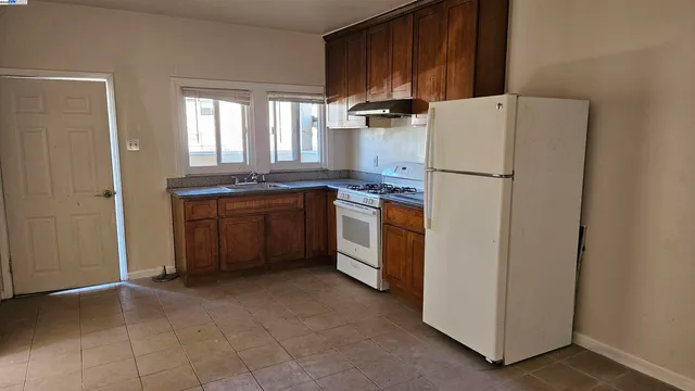 a kitchen with a refrigerator sink and cabinets