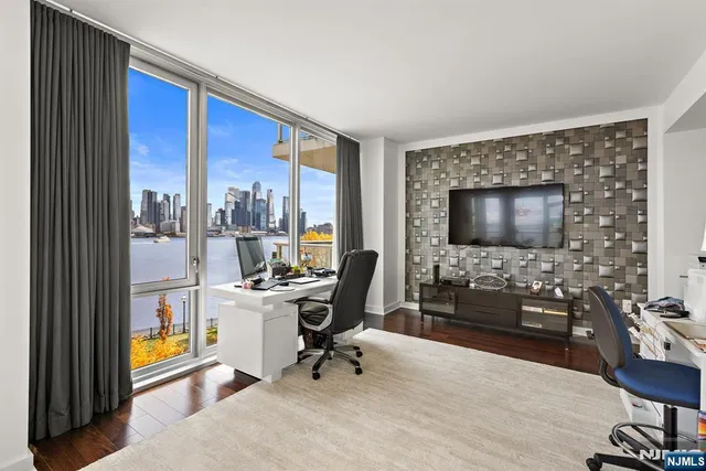 a view of a livingroom with workspace and a window