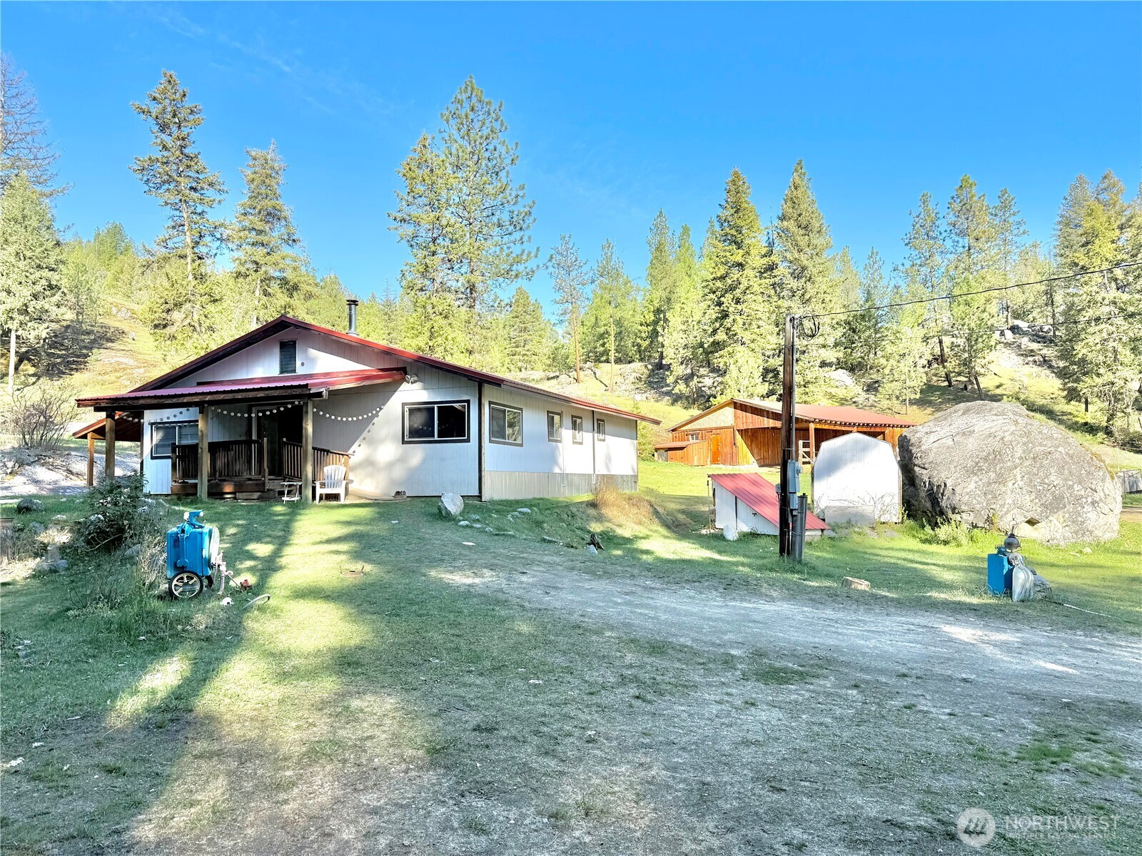 1092 Aeneas Valley Road Tonasket, WA 98855 - Photo 11 of 40 a backyard of a house with barbeque oven table and chairs