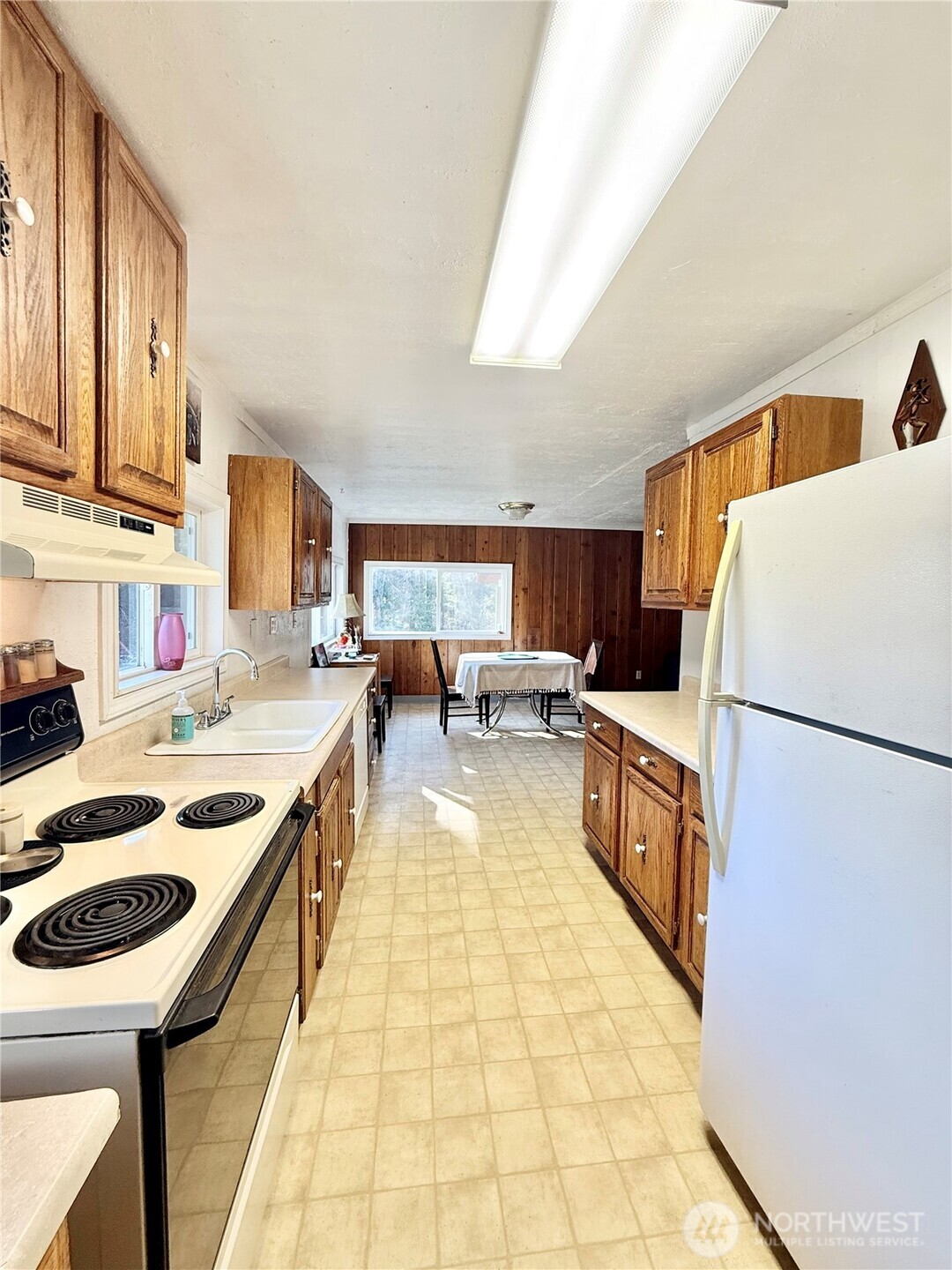 1092 Aeneas Valley Road Tonasket, WA 98855 - Photo 23 of 40 a kitchen with a sink a stove top oven a stove and a refrigerator