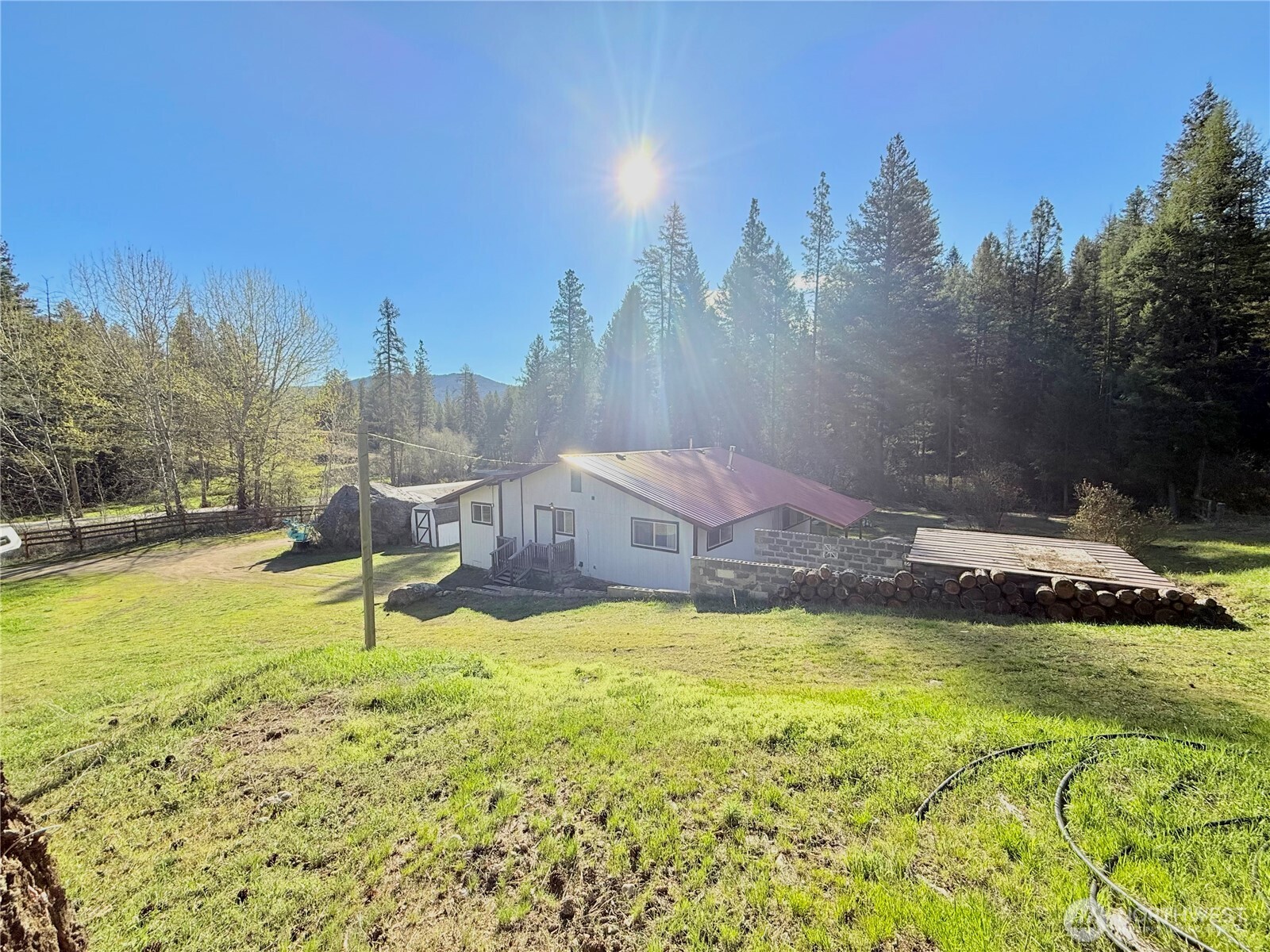 1092 Aeneas Valley Road Tonasket, WA 98855 - Photo 7 of 40 a swimming pool with lawn chairs and wooden fence