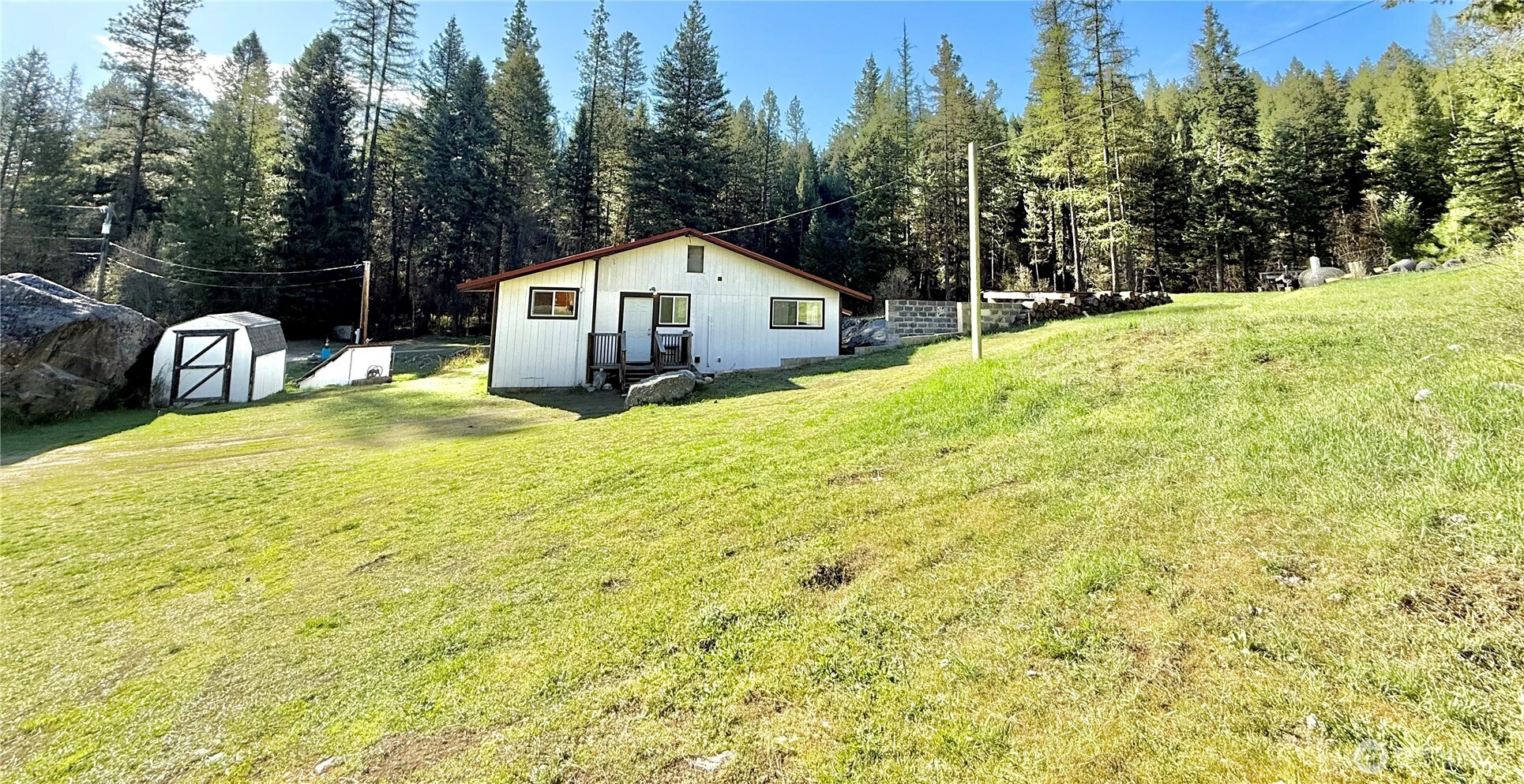 1092 Aeneas Valley Road Tonasket, WA 98855 - Photo 10 of 40 a front view of a house with large trees