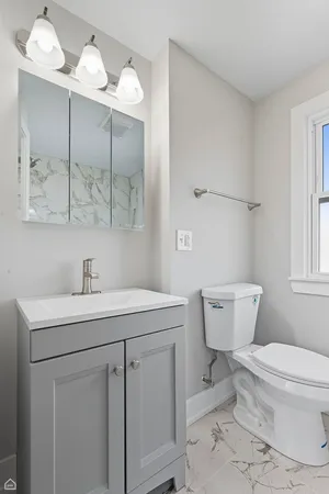 a bathroom with a toilet sink and mirror