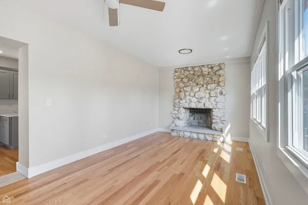 a view of an empty room with a fireplace and a window