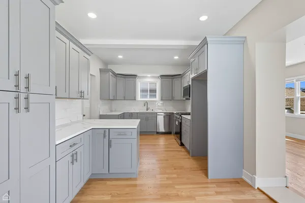 a kitchen with white cabinets appliances and sink