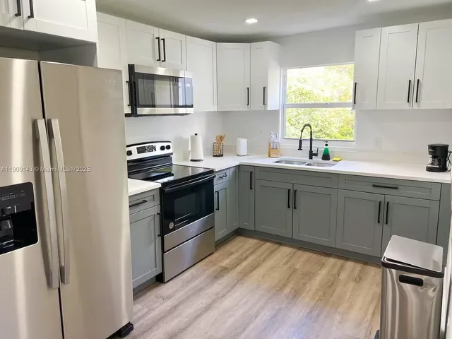 a kitchen with a sink appliances and cabinets