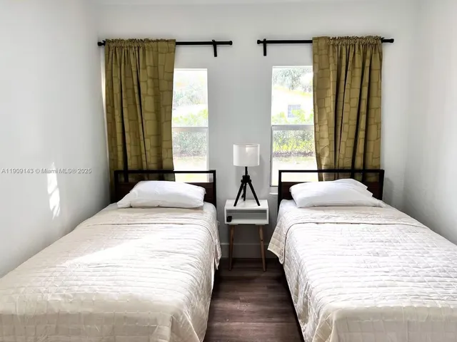 a spacious bedroom with a bed and a large mirror