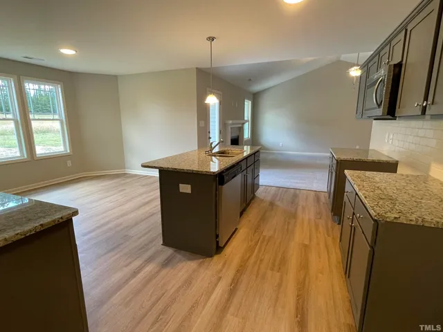 a kitchen with granite countertop a sink counter top space and wooden floor