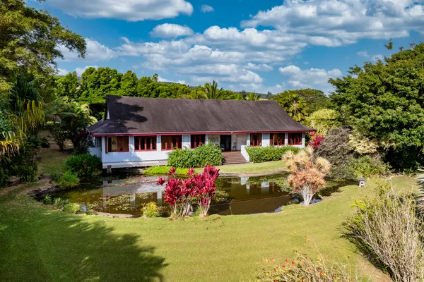 a front view of a house with yard and swimming pool