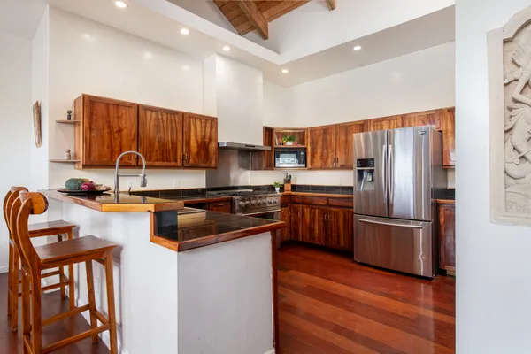 a kitchen with granite countertop a refrigerator stove top oven and sink