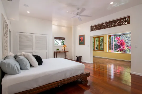 a bedroom with a bed and wooden floor