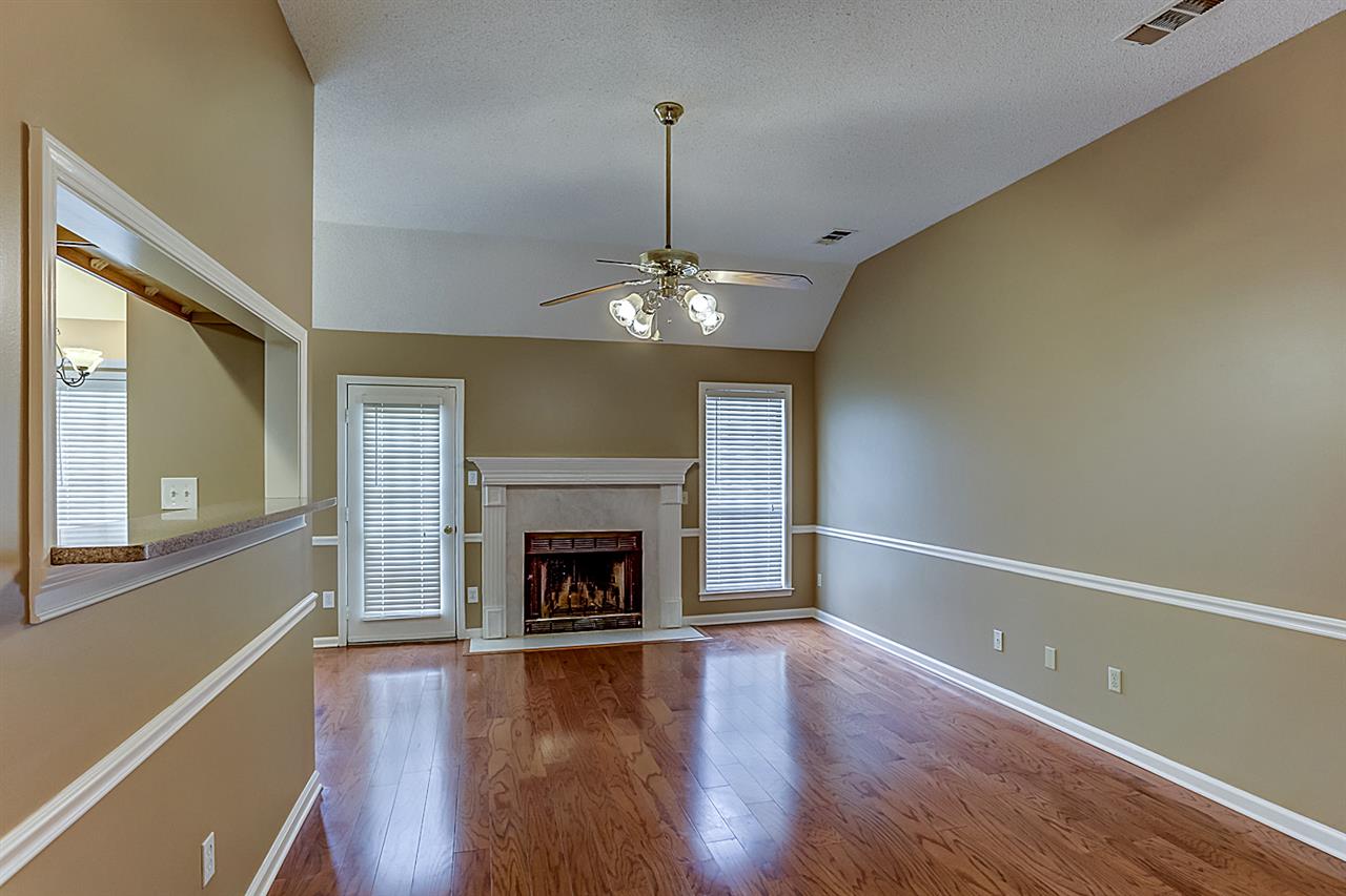 9445 Pleasant Ridge Road Lakeland, TN 38002 - Photo 5 of 21 This open floorplan has TWO large living rooms. This 19x11 Living area has a wood fireplace with custom mantle, hardwood floor,2 inch blinds, vaulted ceiling with fan/light. Separate entrance to the backyard.