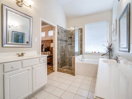 a spacious bathroom with a double vanity sink a mirror and a bathtub