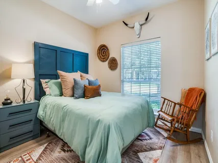 a bedroom with a bed chair and a window