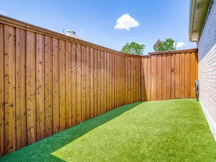a view of a backyard with wooden fence