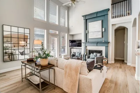 a living room with furniture a fireplace and a floor to ceiling window