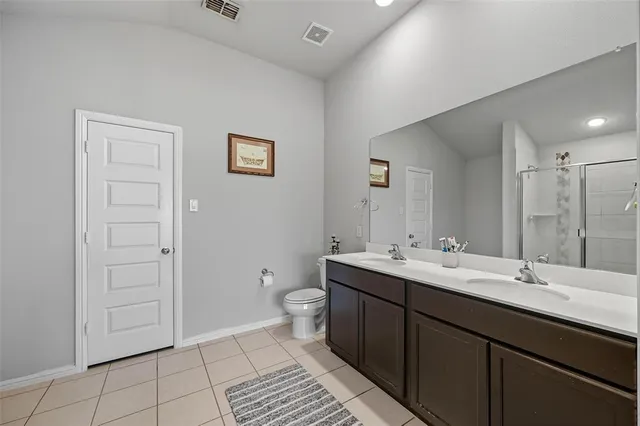 a bathroom with a double vanity sink mirror and toilet