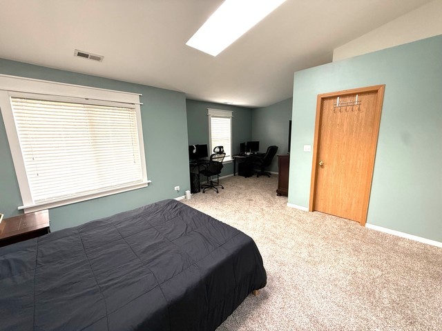 2298 Reflections Drive, Unit 2298 Aurora, IL 60502 - Photo 15 of 26 a bed sitting in a spacious bedroom next to a window
