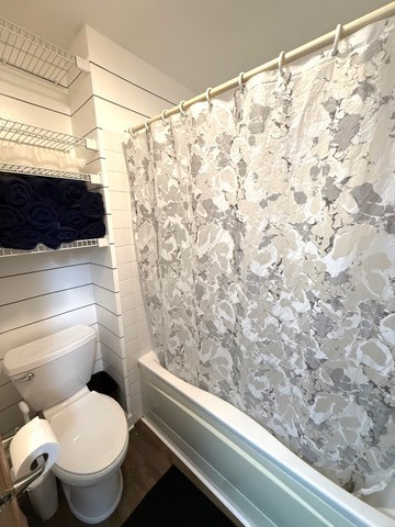 2298 Reflections Drive, Unit 2298 Aurora, IL 60502 - Photo 20 of 26 a bathroom with a toilet and a shower curtain